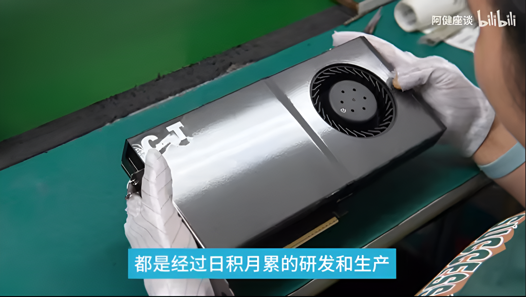 Worker assembling a GPU with precision on a green workbench.