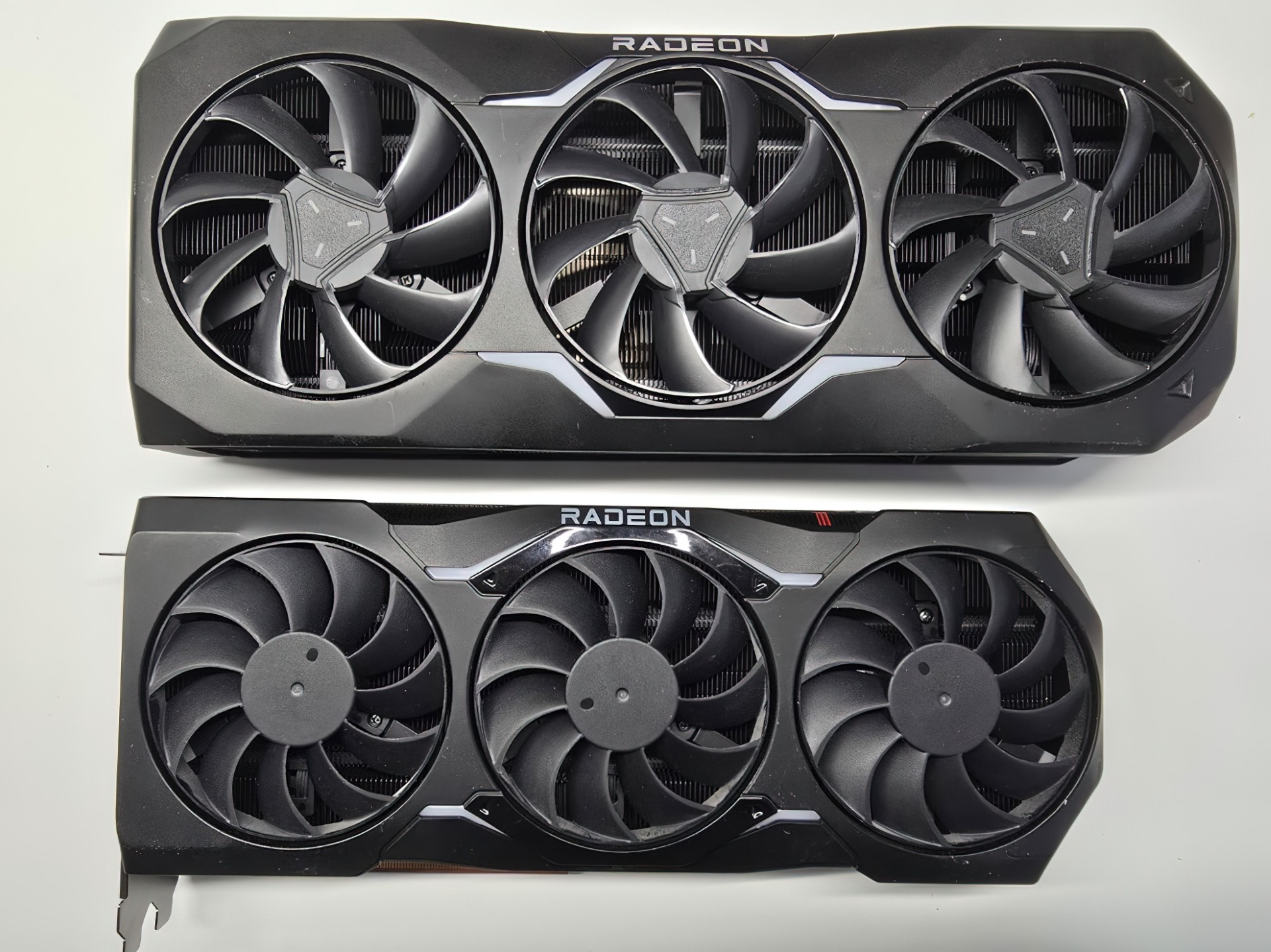 Two Radeon graphics cards with triple cooling fans on a white background.