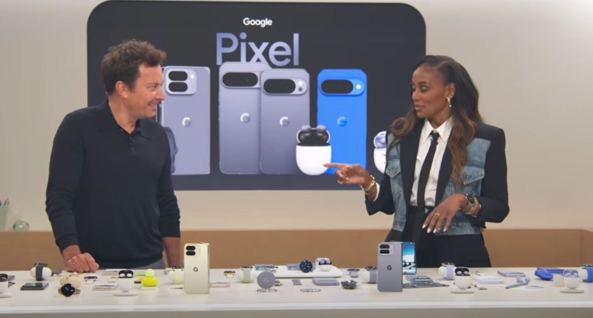 Two people discussing Google Pixel smartphones and accessories at a tech display event.