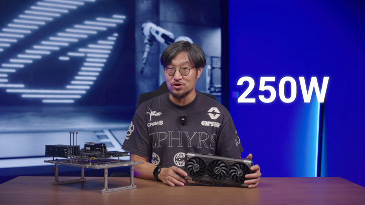 Man holds unbranded graphics card on stage with 250W displayed on screen.