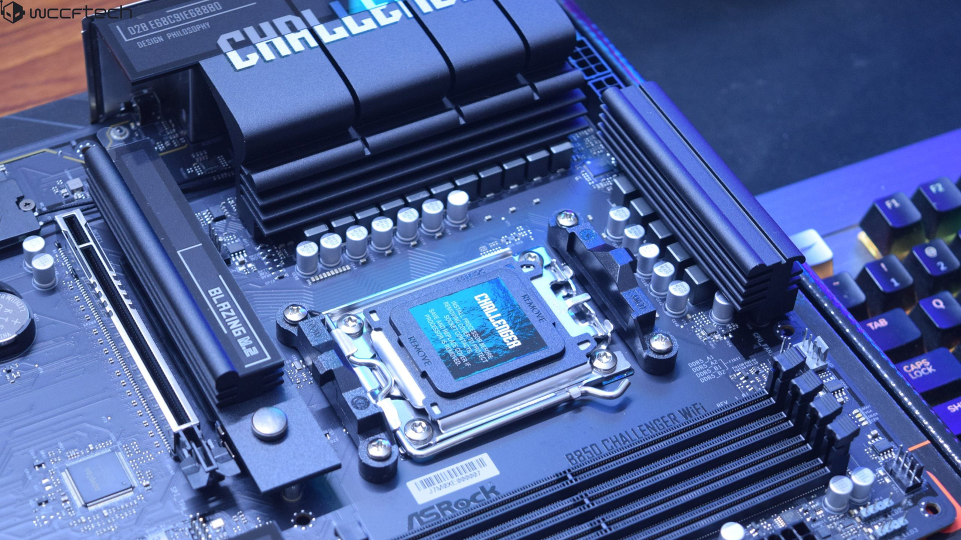 ASRock B650E Challenger WiFi motherboard on a desk with visible Blazing M2 slot.