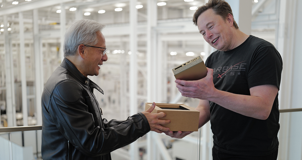 Two people exchange a NVIDIA Jetson box in a tech facility.