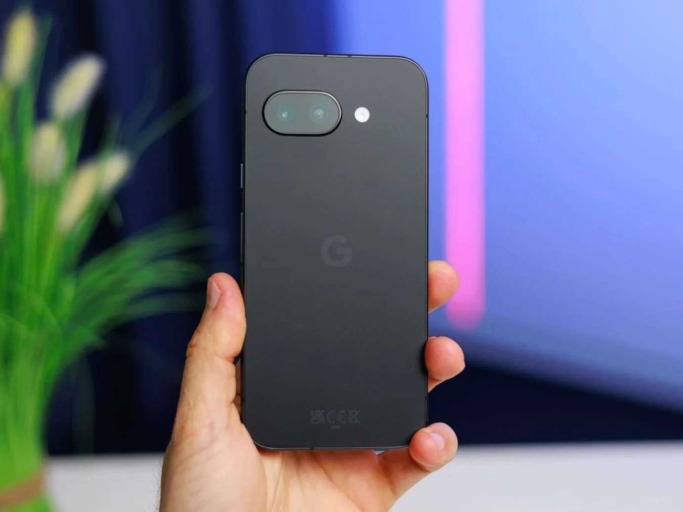 Google Pixel smartphone in hand, blurred background.