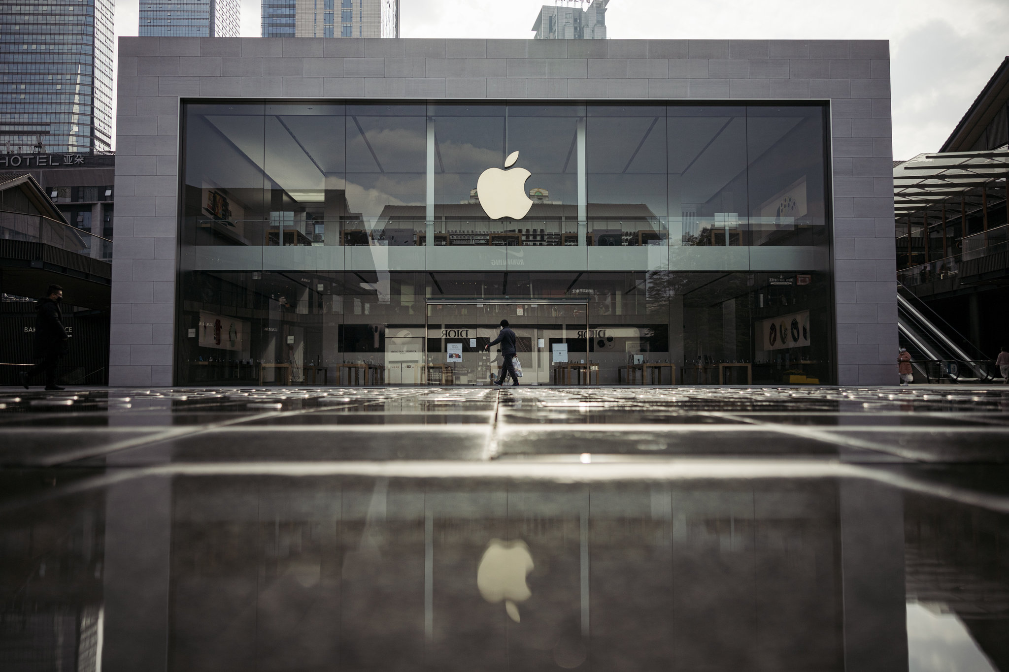 Apple Store exterior with large logo, city setting.