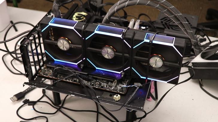 A Sapphire graphics card setup with LED lighting is displayed on a test bench with various cables connected.