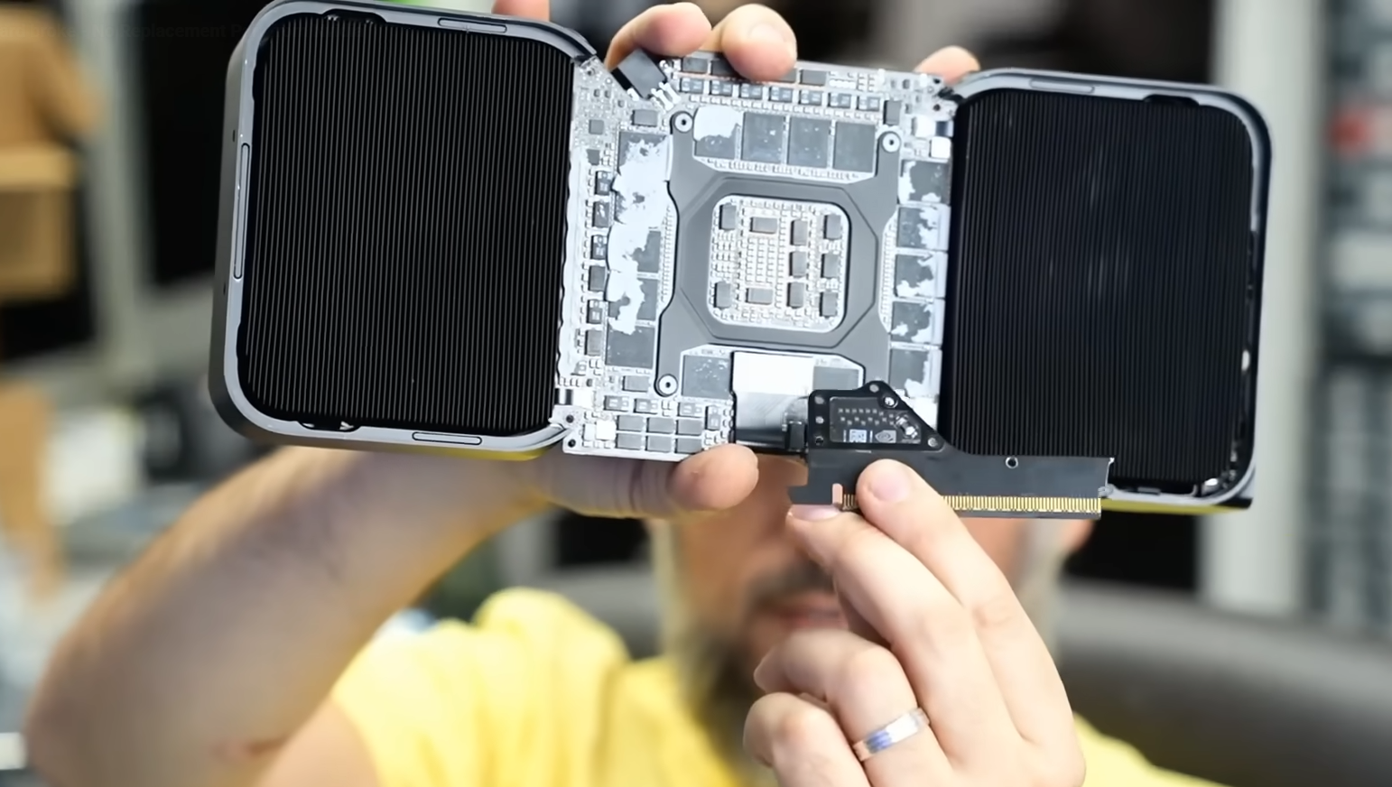 A person holding an open NVIDIA graphics card, revealing its internal heatsinks and circuit board.