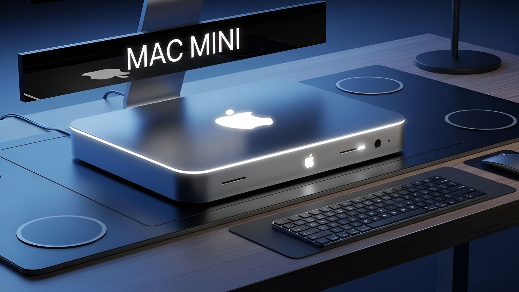 An Apple Mac Mini on a desk, with a glowing Apple logo and 'MAC MINI' above it, accompanied by a keyboard and mouse.