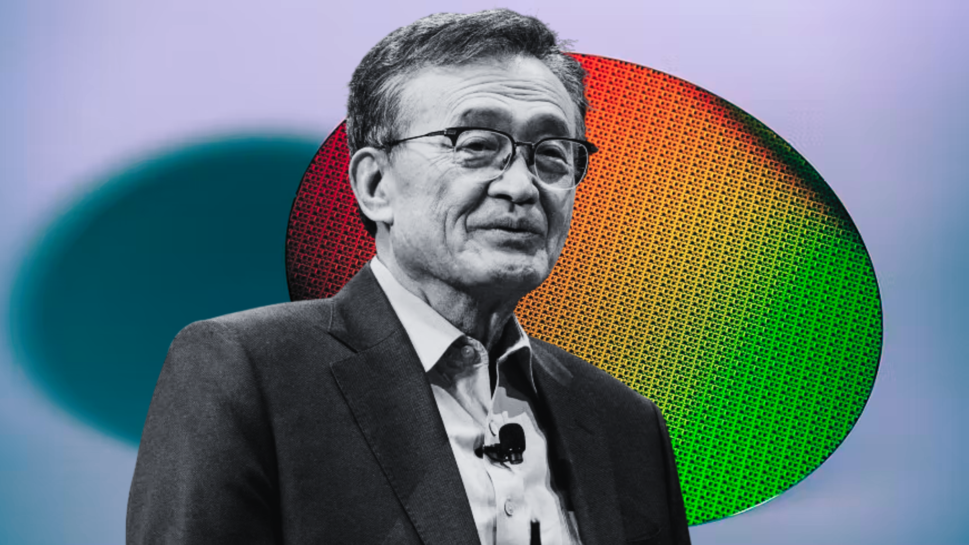 A person in a suit stands in front of a colorful semiconductor wafer backdrop.