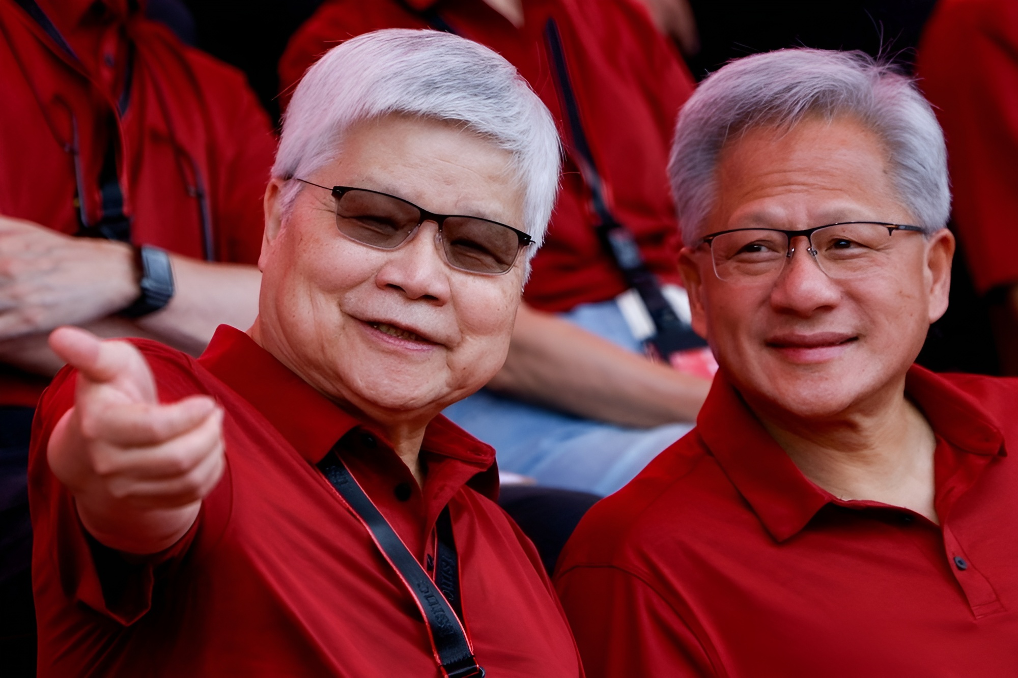 Two individuals in red shirts smiling at an event.