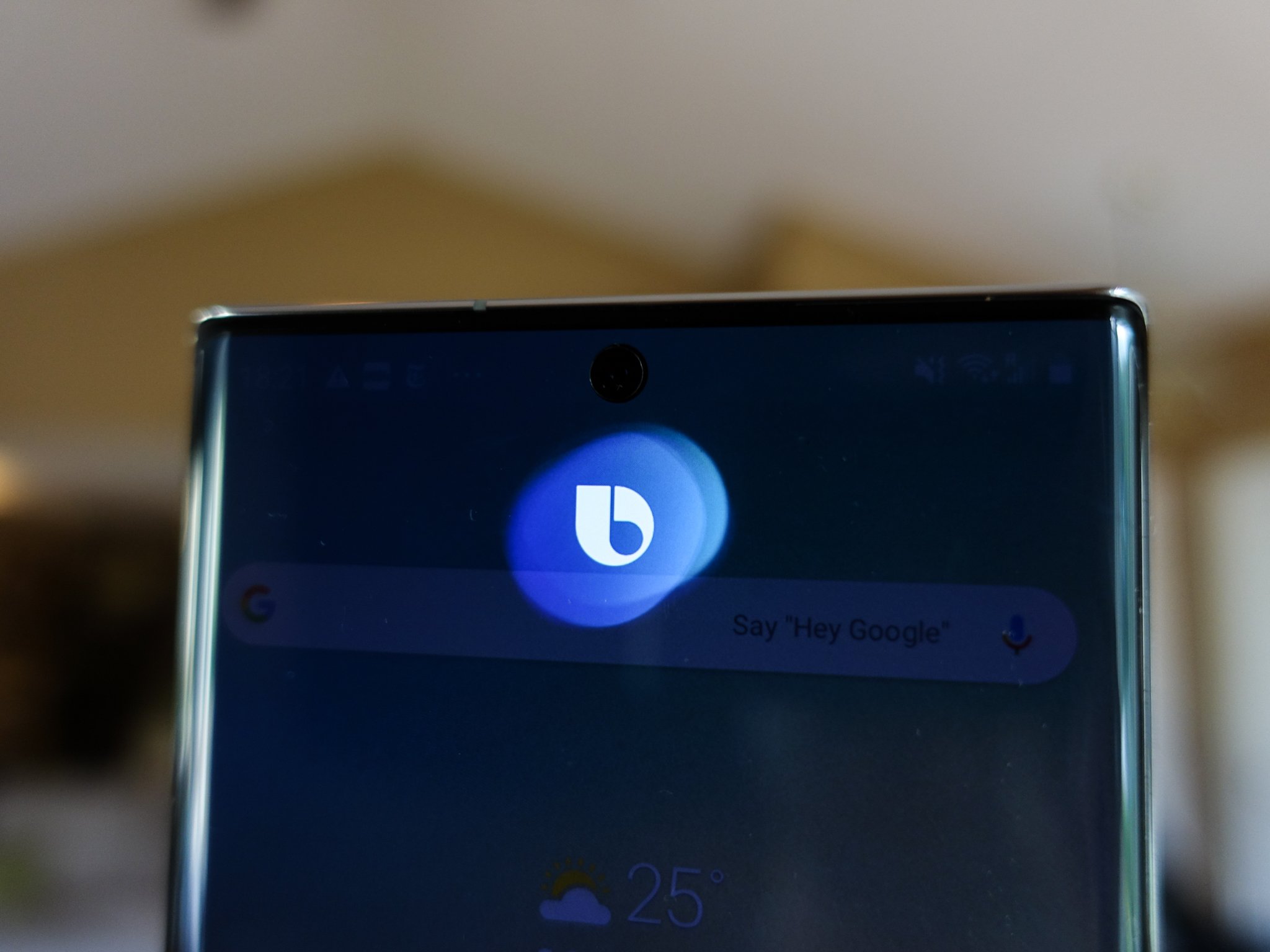 The top portion of a Samsung Galaxy smartphone shows the Bixby logo and a Google search bar with the prompt 'Say Hey Google.'