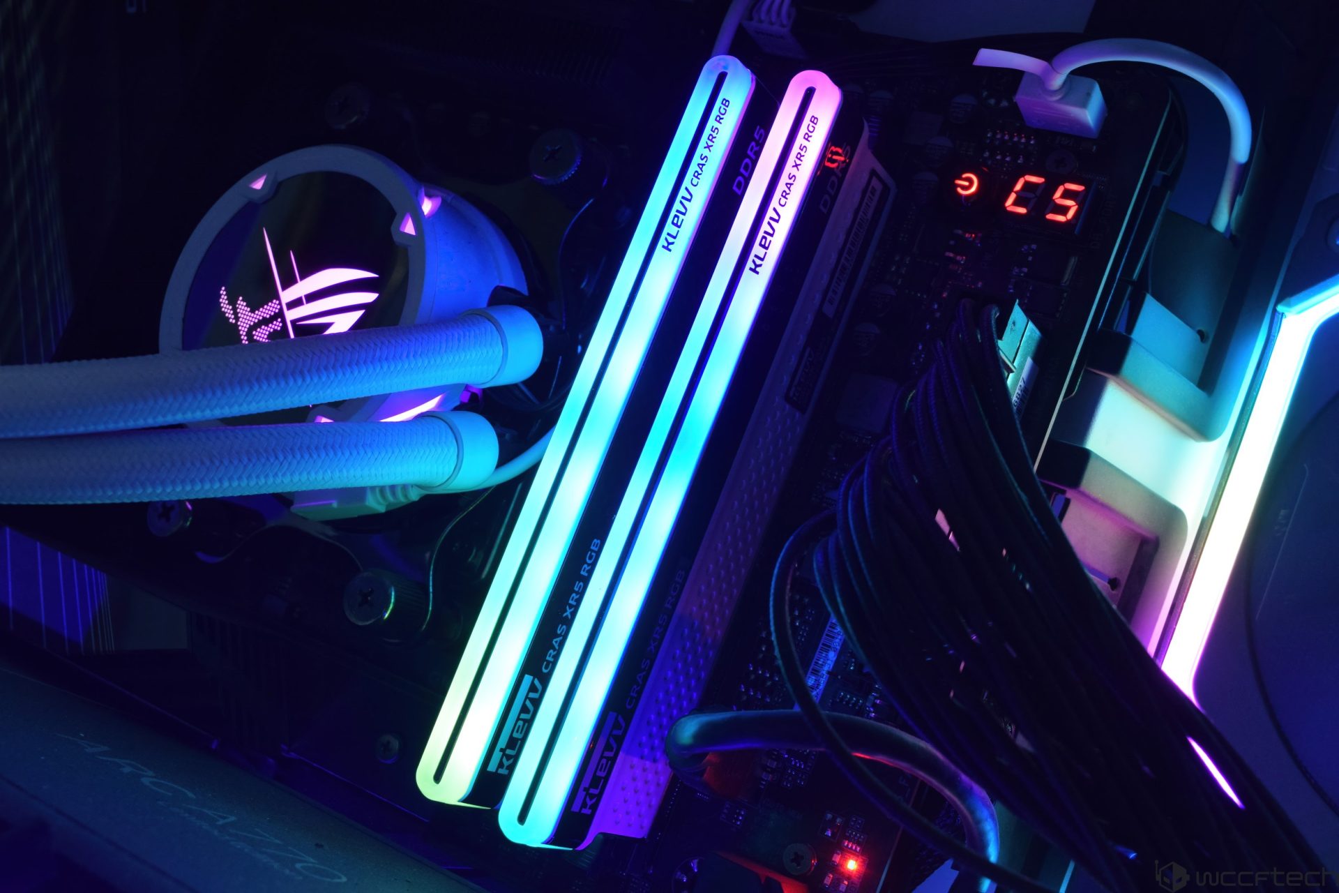 Close-up of a PC build featuring dual KLEVV CRAS XR5 RGB DDR5 RAM sticks and an illuminated ASUS ROG cooler.