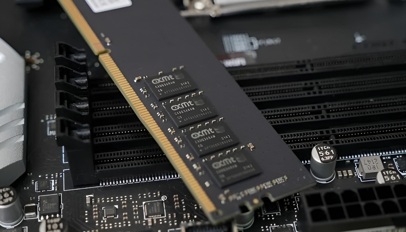 A stick of OCM memory RAM is inserted into a motherboard's DIMM slot, with four visible RAM chips labeled with the OCM logo.