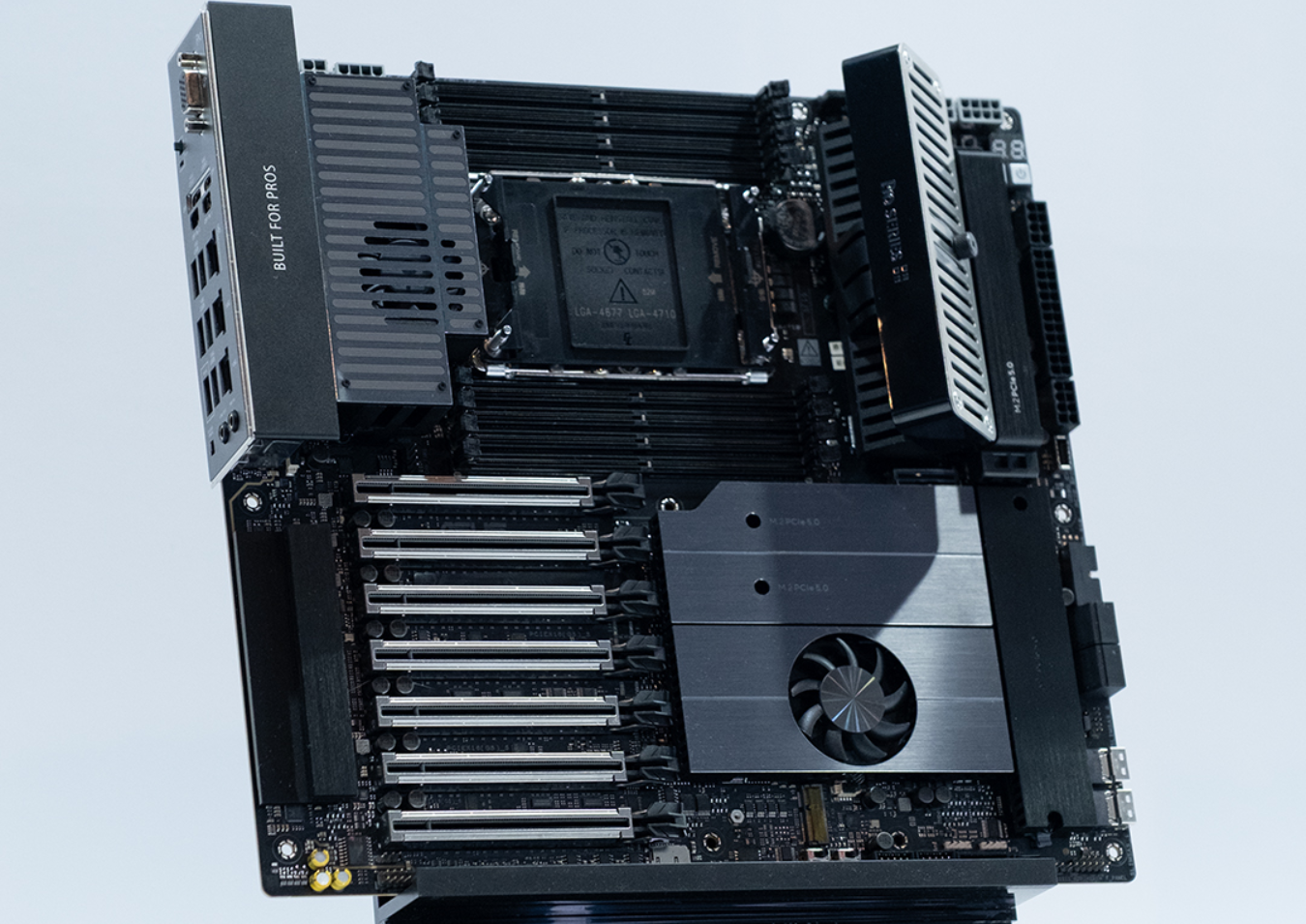 An unbranded motherboard features multiple PCIe slots, cooling fans, and the text 'Built for Pros' on a visible component.