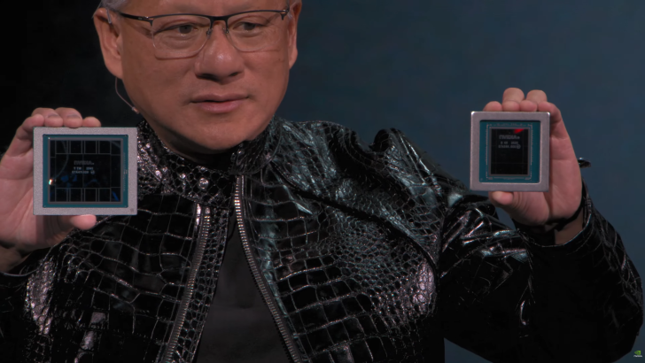 A person holding two NVIDIA Blackwell chips, with text on the left chip reading 'NVIDIA H100 T1' and on the right chip reading 'NVIDIA B100 2025 0242A2M00.'