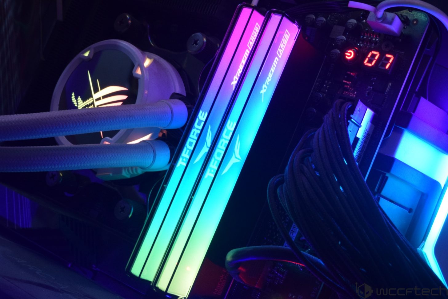 A pair of T-Force Xtreem ARGB RAM modules with RGB lighting are installed in a gaming PC next to an ASUS ROG CPU cooler with illuminated logo.