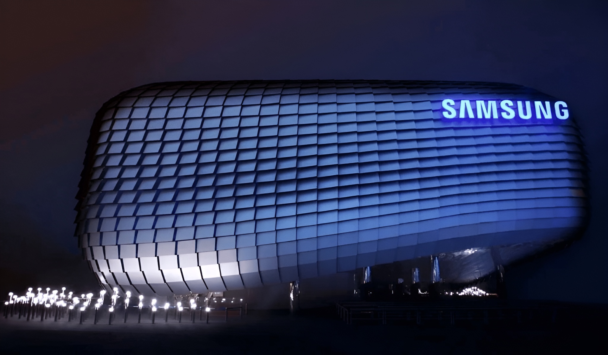 Futuristic Samsung building with illuminated logo and modern architectural design at night.