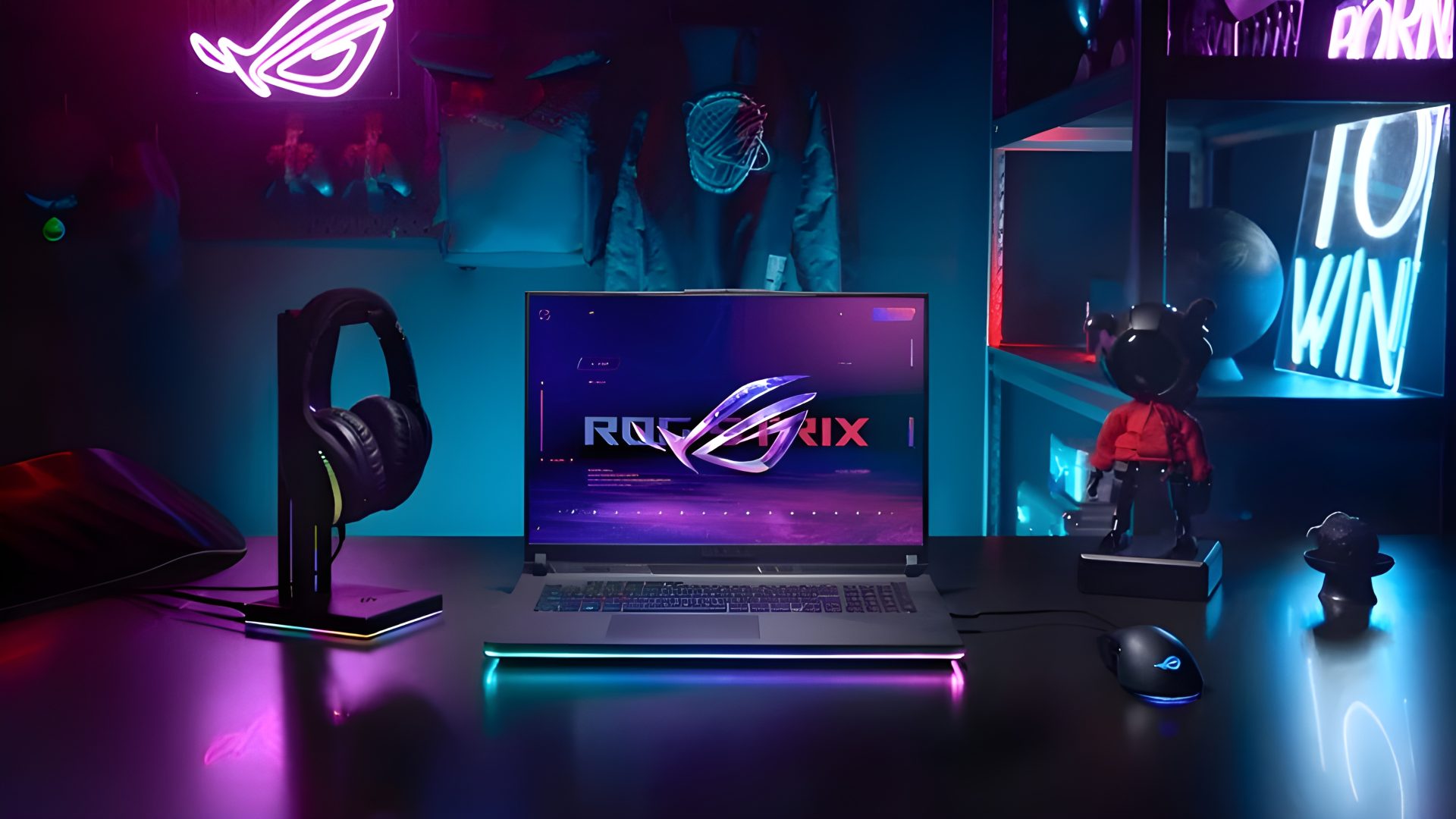 An ASUS ROG Strix gaming laptop is displayed on a desk with 'ROG STRIX' on its screen, surrounded by ROG headphones, a gaming mouse, and neon lights in a dimly lit gaming setup.