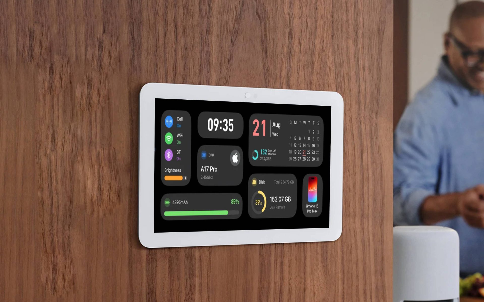 A wall-mounted screen displays various widgets including 'A17 Pro,' '09:35,' 'iPhone 15 Pro Max,' and battery information