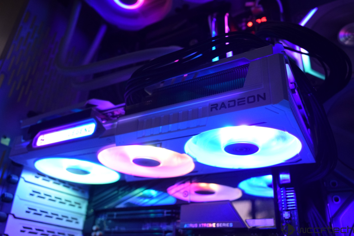A graphics card labeled RADEON with RGB fans inside a computer setup featuring AORUS XTREME SERIES components.