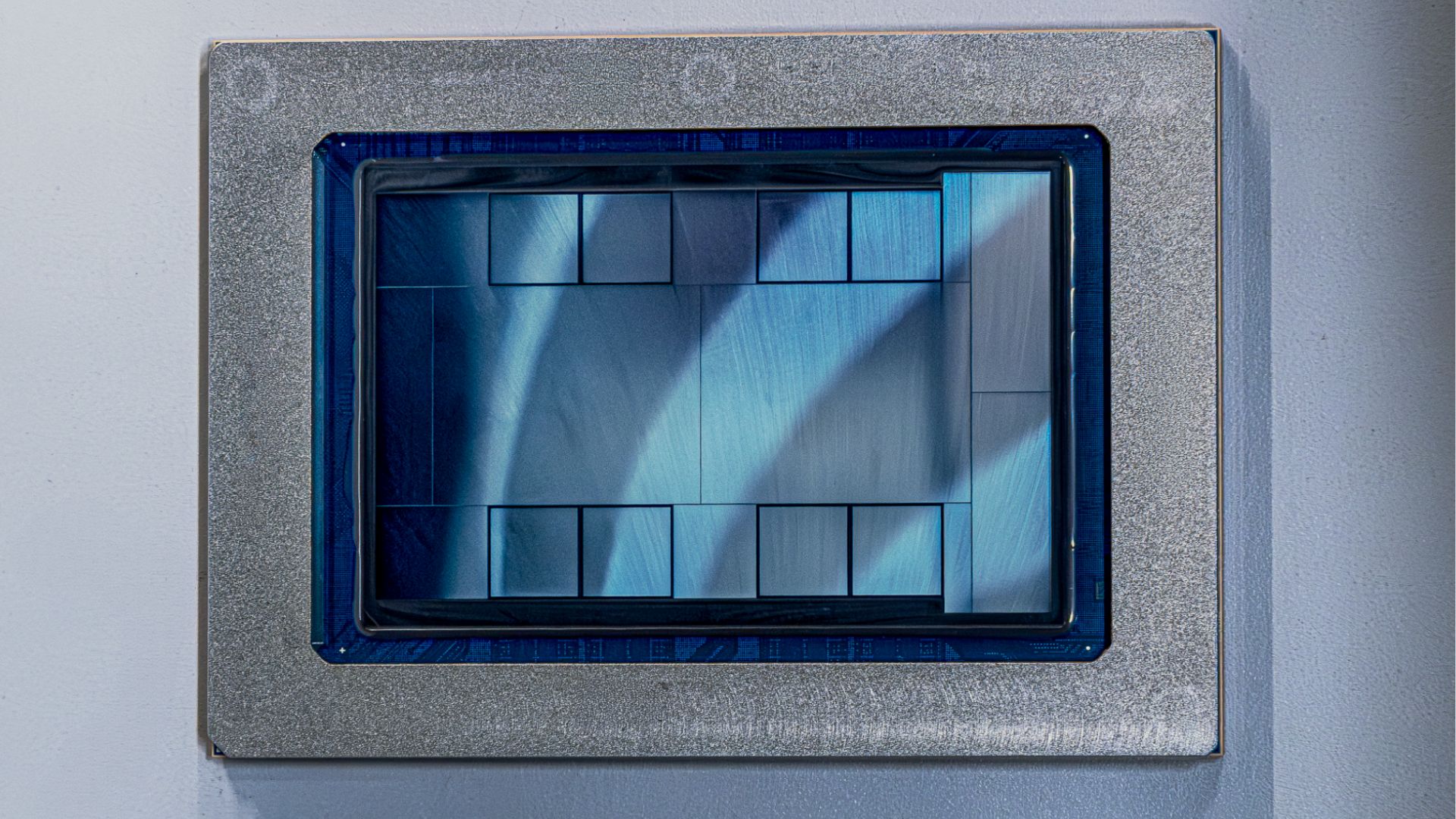 Close-up of a computer chip with a blue and silver pattern encased in a metallic frame.