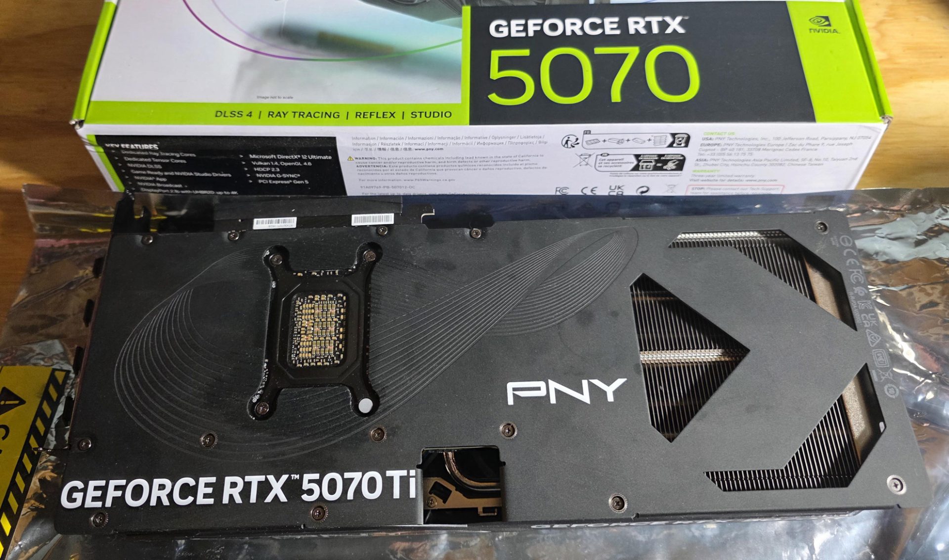 A PNY GeForce RTX 5070 Ti graphics card is displayed above its packaging which features the text 'DLSS 4