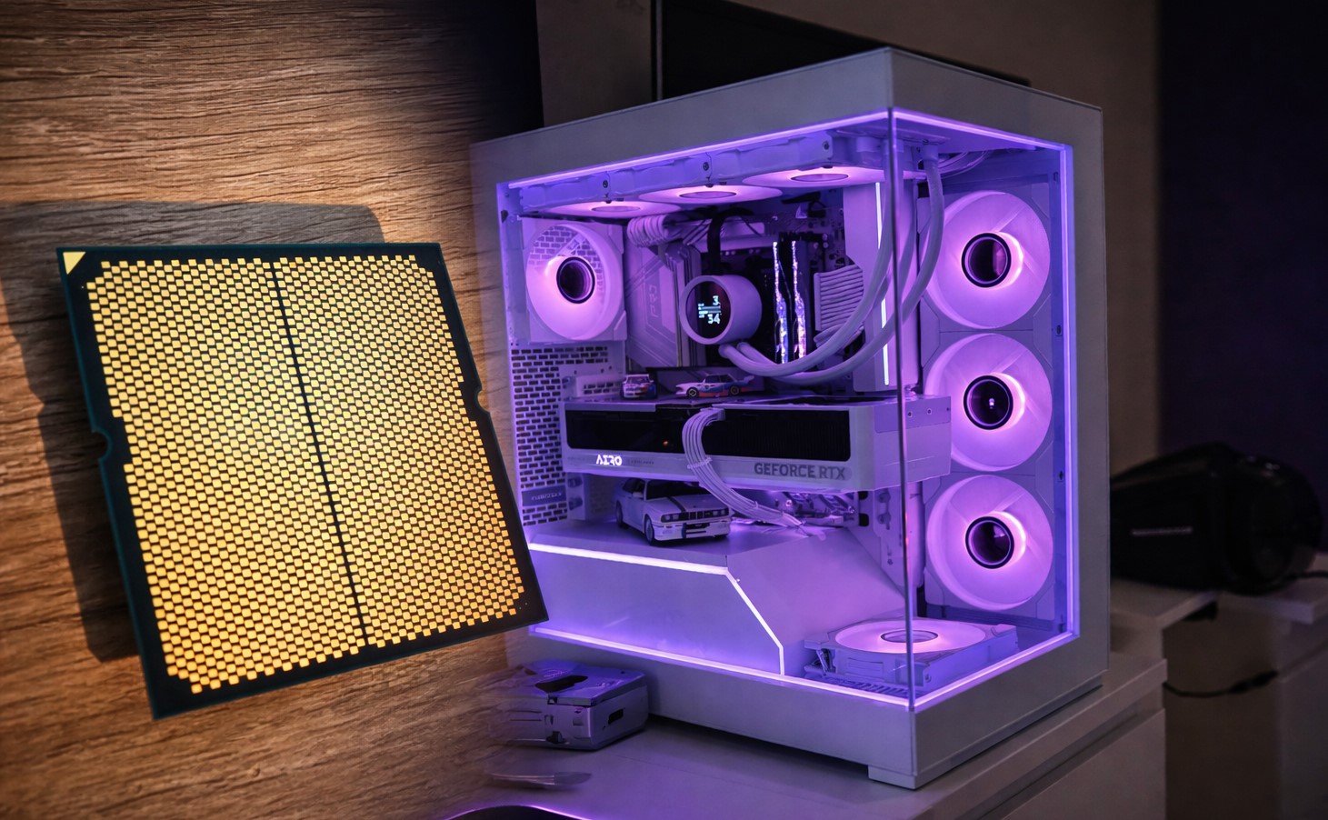 A clear desktop PC with a 'GeForce RTX' GPU and liquid cooling setup glows with purple LED lighting beside a large, unbranded, LGA-style processor on a wooden surface.