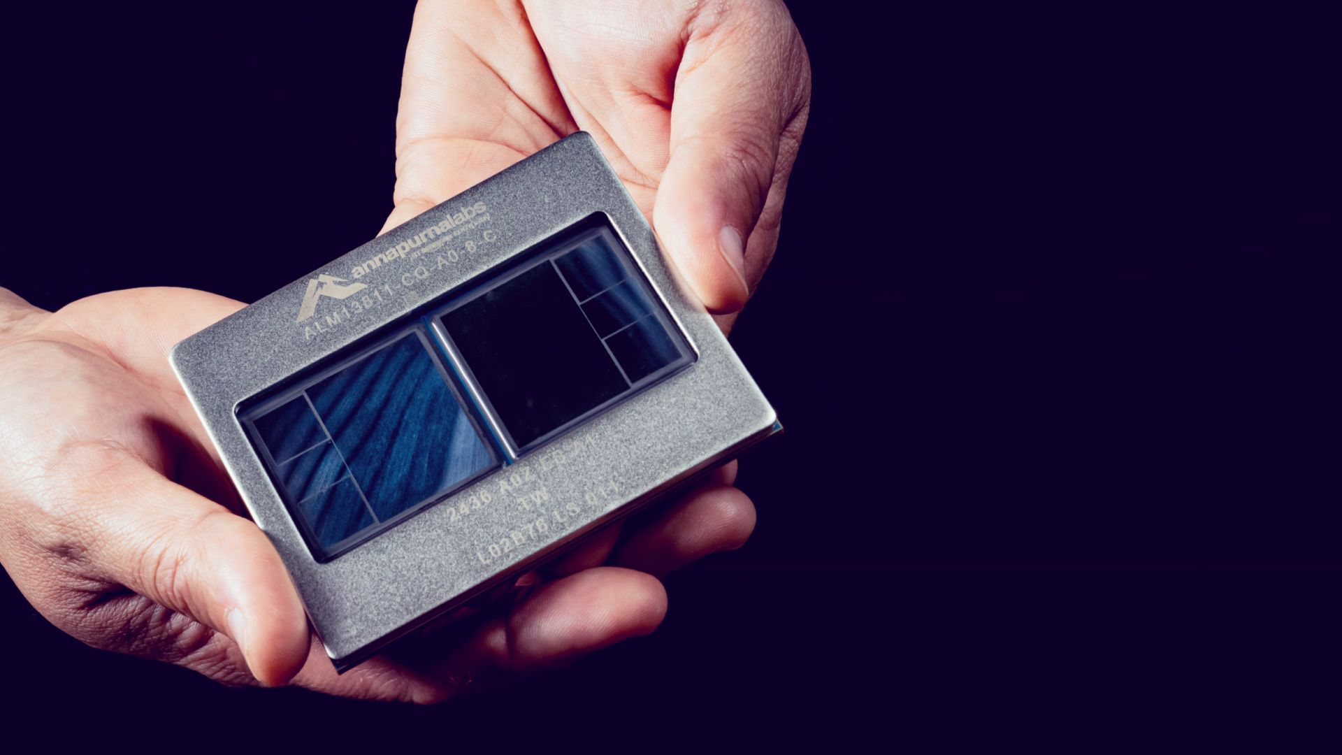 A person holding a chip with the logo 'annapurnalabs' and model number 'ALM-B211.'