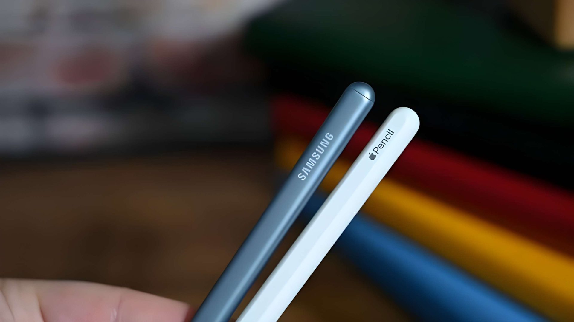 Close-up of a Samsung stylus and an Apple Pencil held together, showing the brand names.