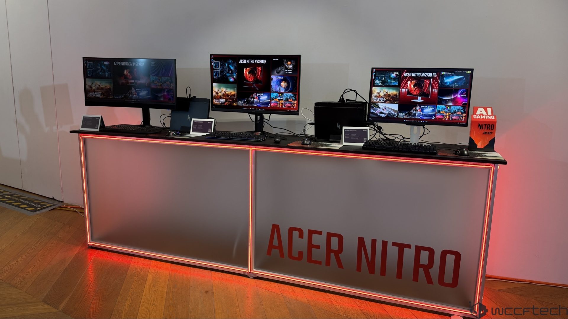 Three Acer Nitro monitors, models 'XV2SU P,' 'XV3 QD QX,' and 'XV3 ZQ F5,' are displayed on a lit counter labeled 'ACER NITRO' alongside AI Gaming signage.
