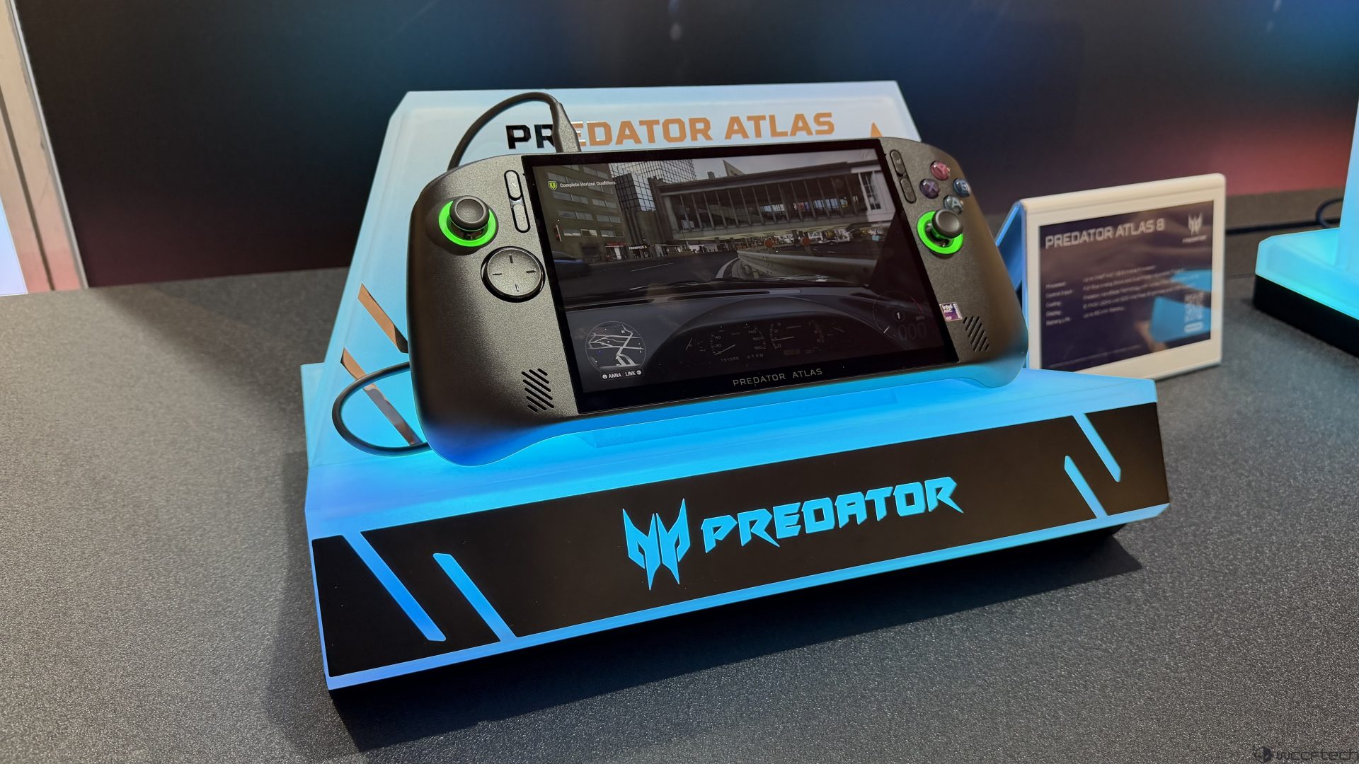 The Predator Atlas gaming handheld is displayed showing a racing game on its screen, with 'PREDATOR ATLAS 8' visible on the stand.