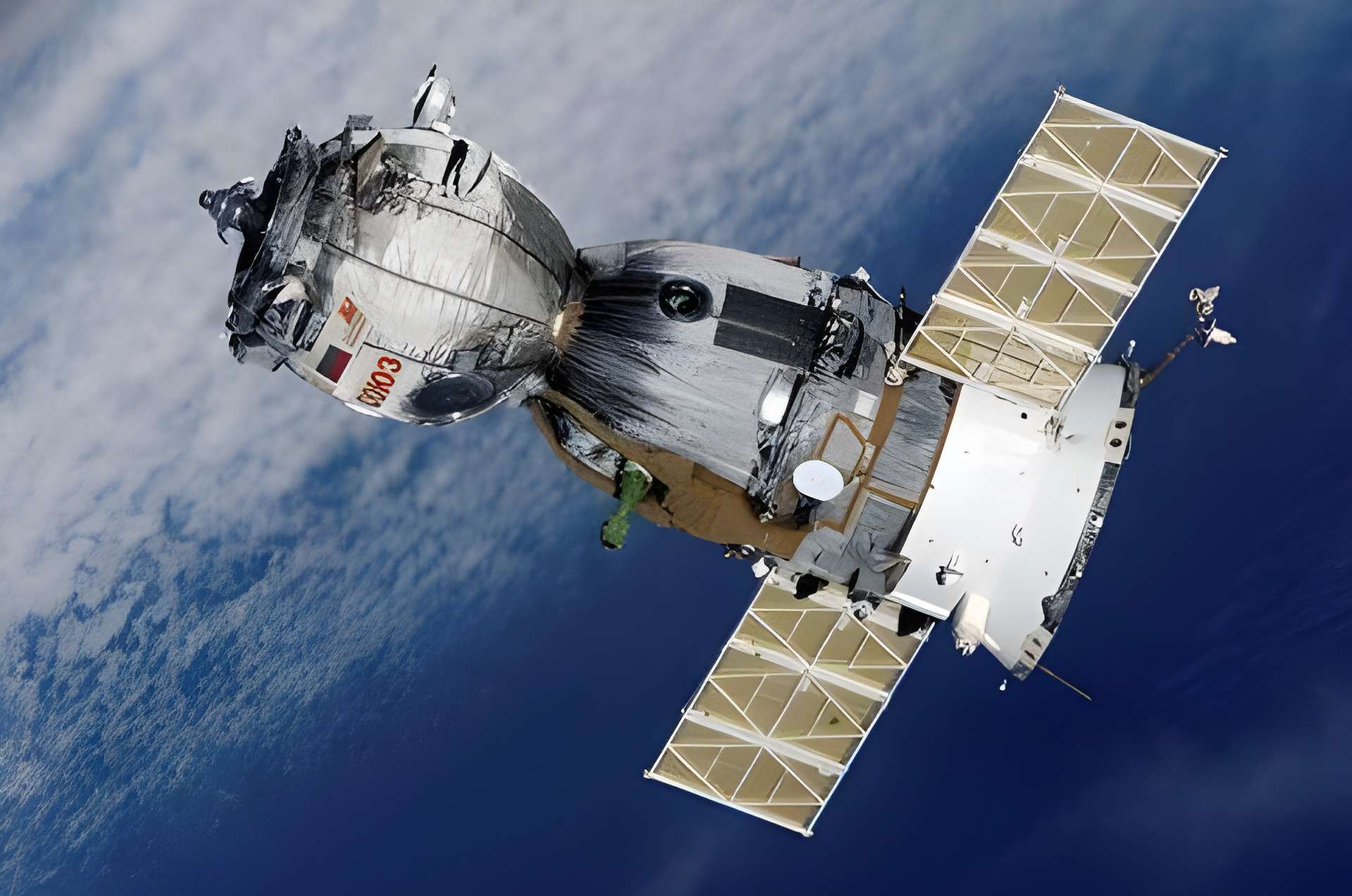 A Soviet Soyuz spacecraft orbiting Earth with visible solar panels and the USSR flag.