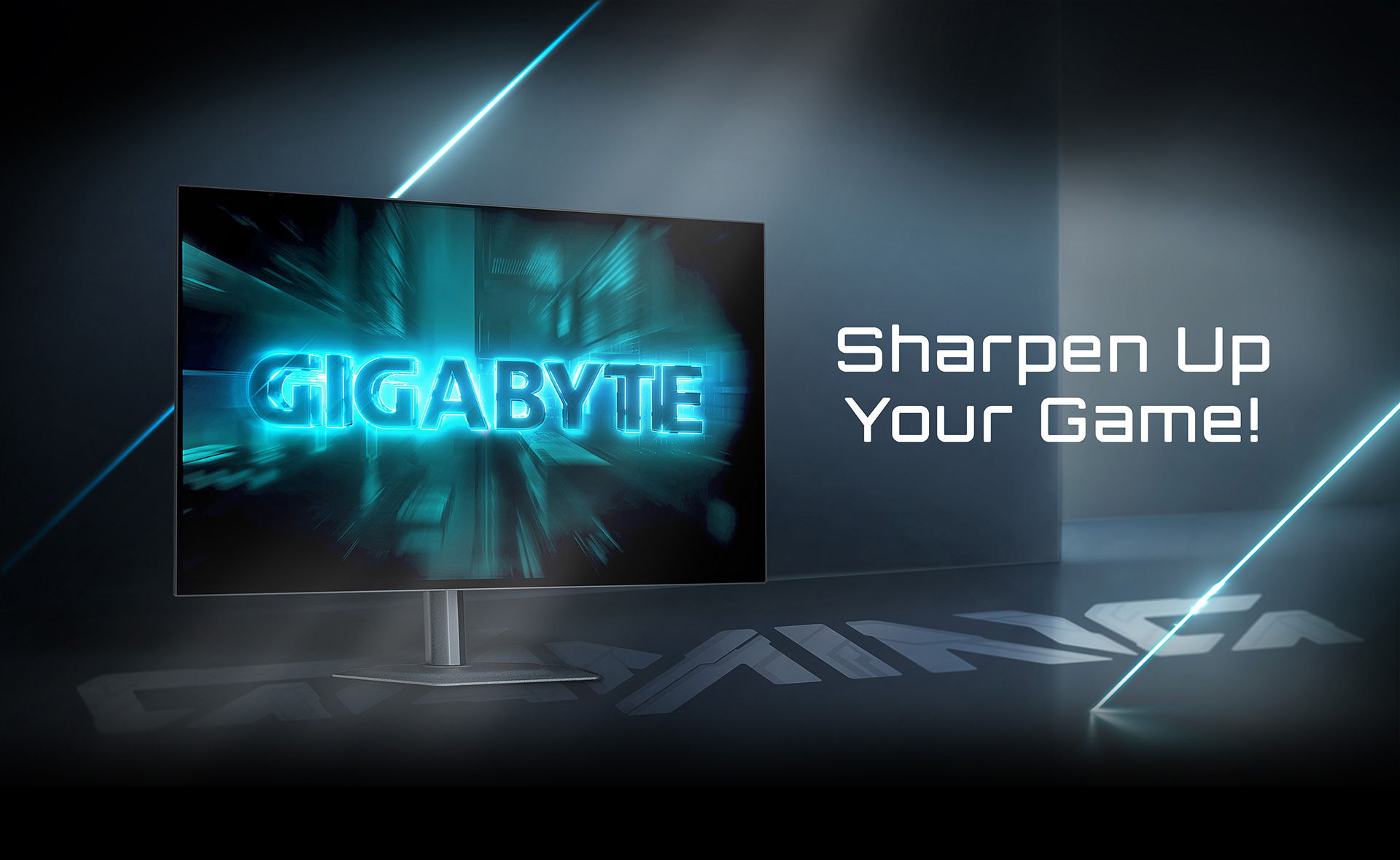 A GIGABYTE gaming monitor displays the text 'Sharpen Up Your Game!' in a dark, futuristic room with bright blue lighting.