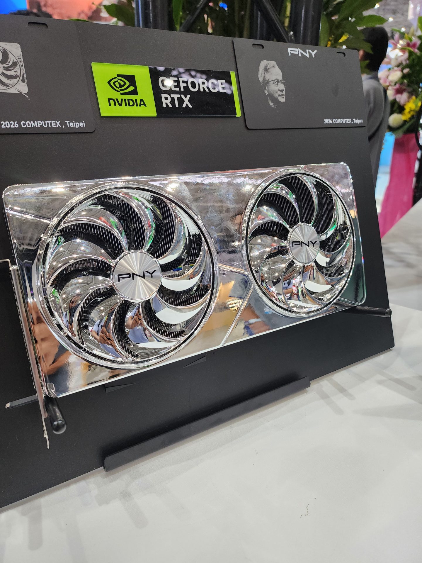 A PNY graphics card featuring dual cooling fans is displayed with a sign indicating NVIDIA GeForce RTX at the 2026 Computex event in Taipei.