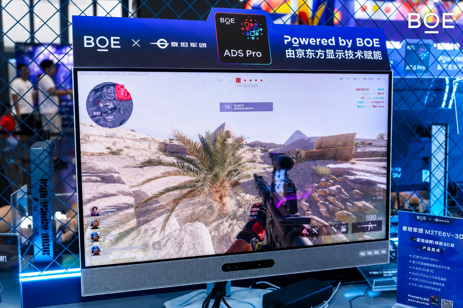 A BOE monitor displays gameplay with a first-person shooter view, labeled 'BOE ADS Pro' on top, and features a sign detailing 'M27E6V-3D.'