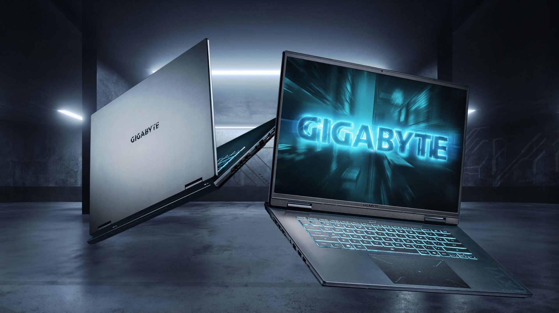 Two Gigabyte laptops with one displaying a glowing GIGABYTE logo on the screen in a dark, futuristic setting.