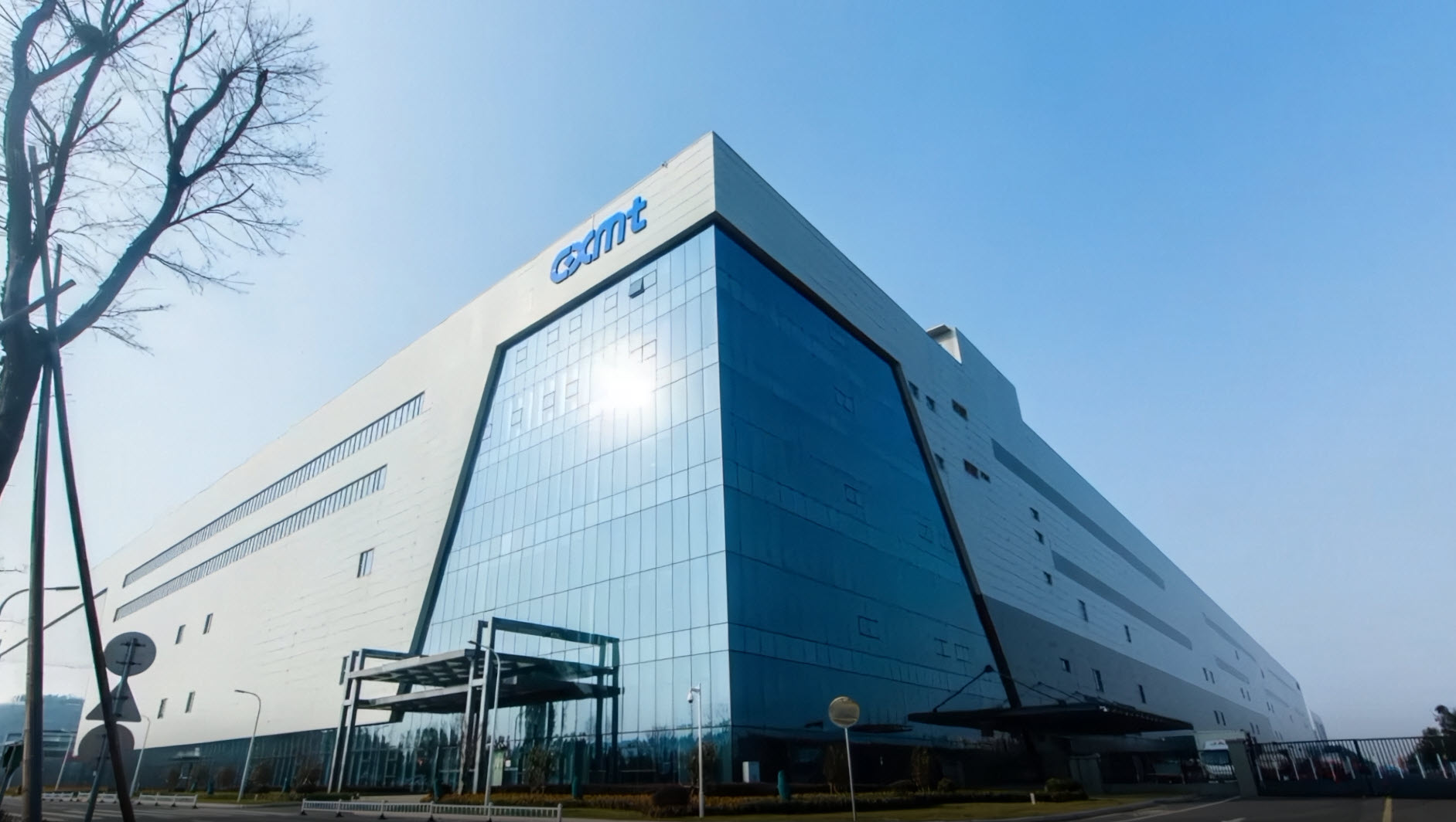 A large, modern building with reflective glass and the 'GSMT' logo on the upper left corner.