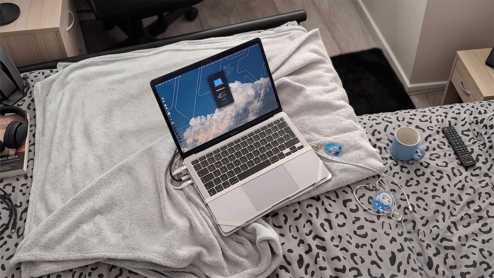Headless M4 Pro MacBook Pro strapped beneath an M1 MacBook Air using rubber bands to use its display via local network streaming