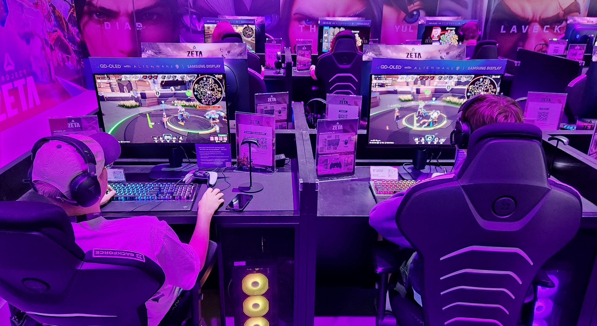 Gamers using Alienware monitors with Samsung QD-OLED displays play a multiplayer game in a setup labeled 'Project Zeta' at a gaming event.