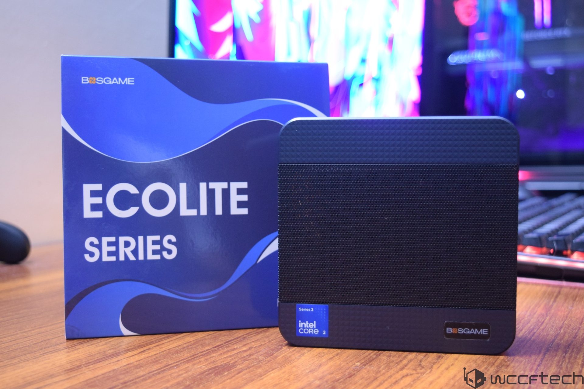 A BSGAME Ecolite Series mini PC with Intel Core i3 is displayed on a wooden surface, accompanied by its packaging box.