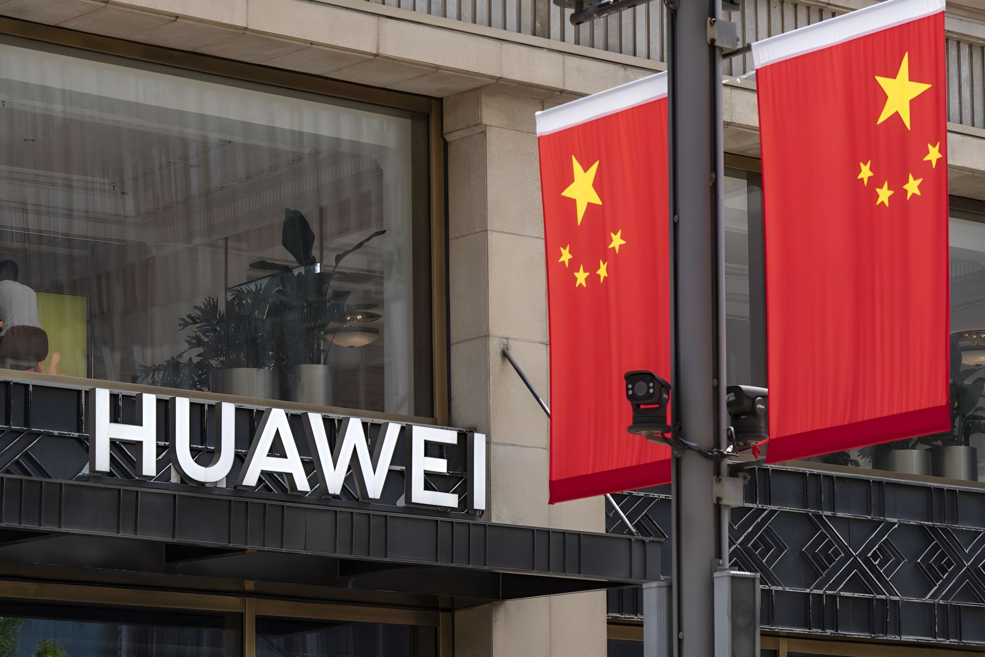 A Huawei store facade is shown next to two Chinese flags on a street pole.