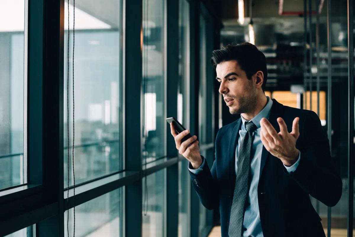 Businessman annoyed with phone call in office