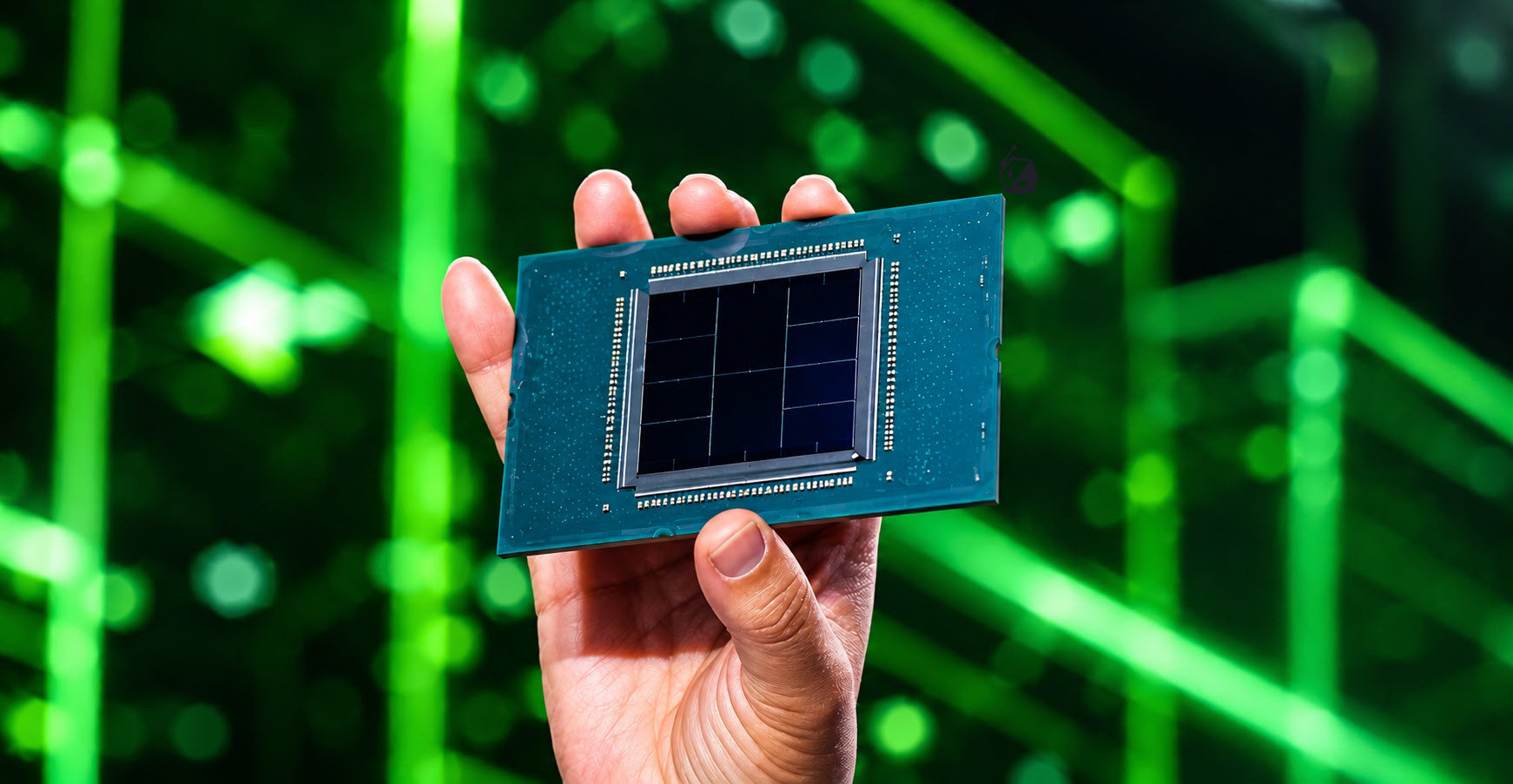 A hand holding an Intel data center chip against a blurred green background.