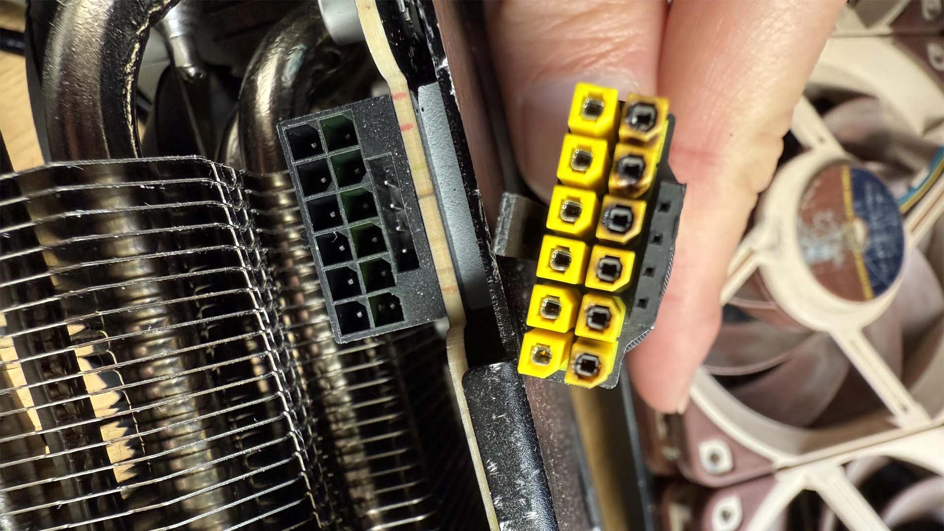A close-up image shows a computer power connector with yellow ends displaying signs of burn damage next to an unconnected socket.