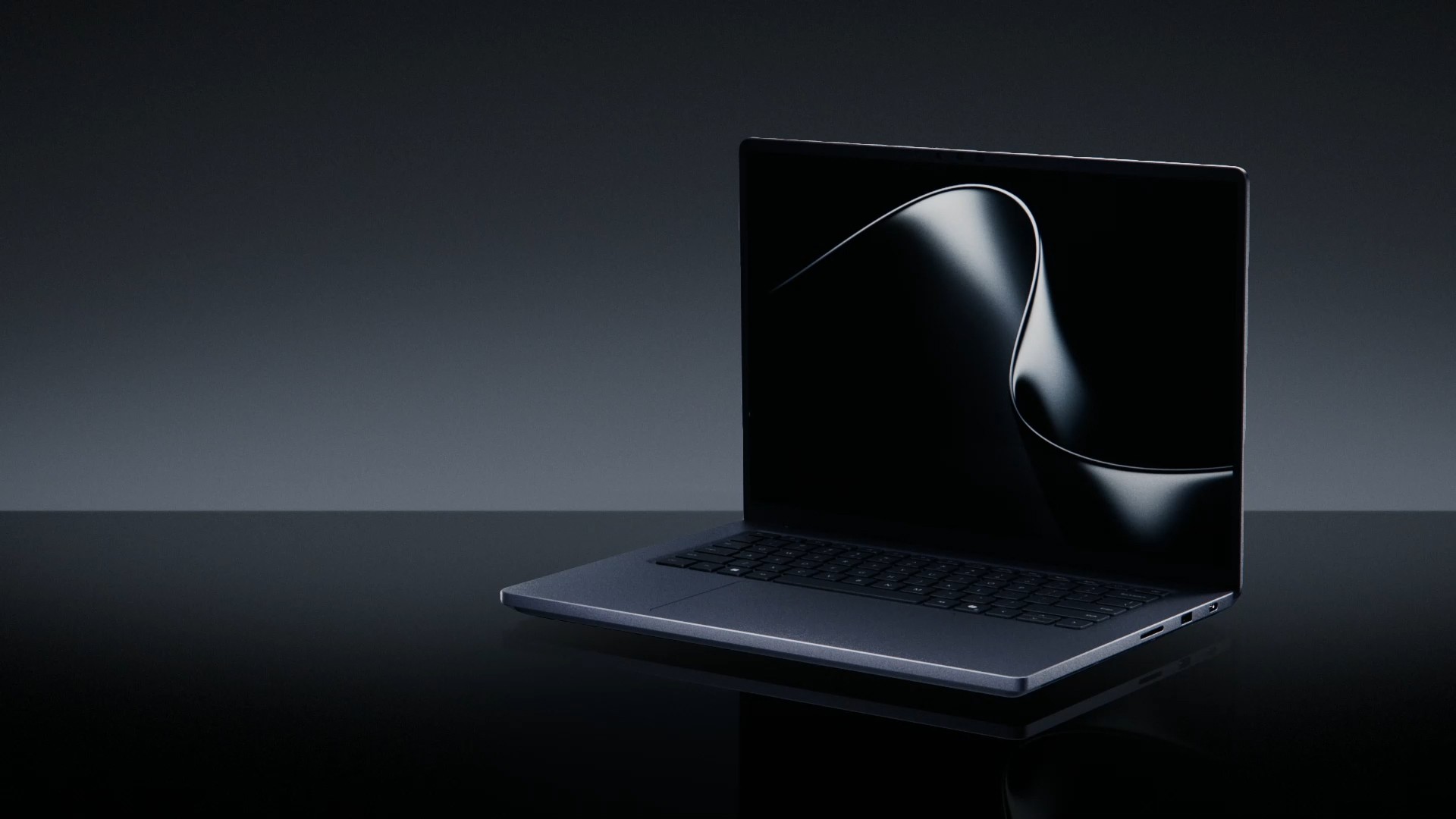 A dark-colored laptop with a sleek design is positioned on a reflective surface, displaying an abstract black and silver swirl pattern on its screen.